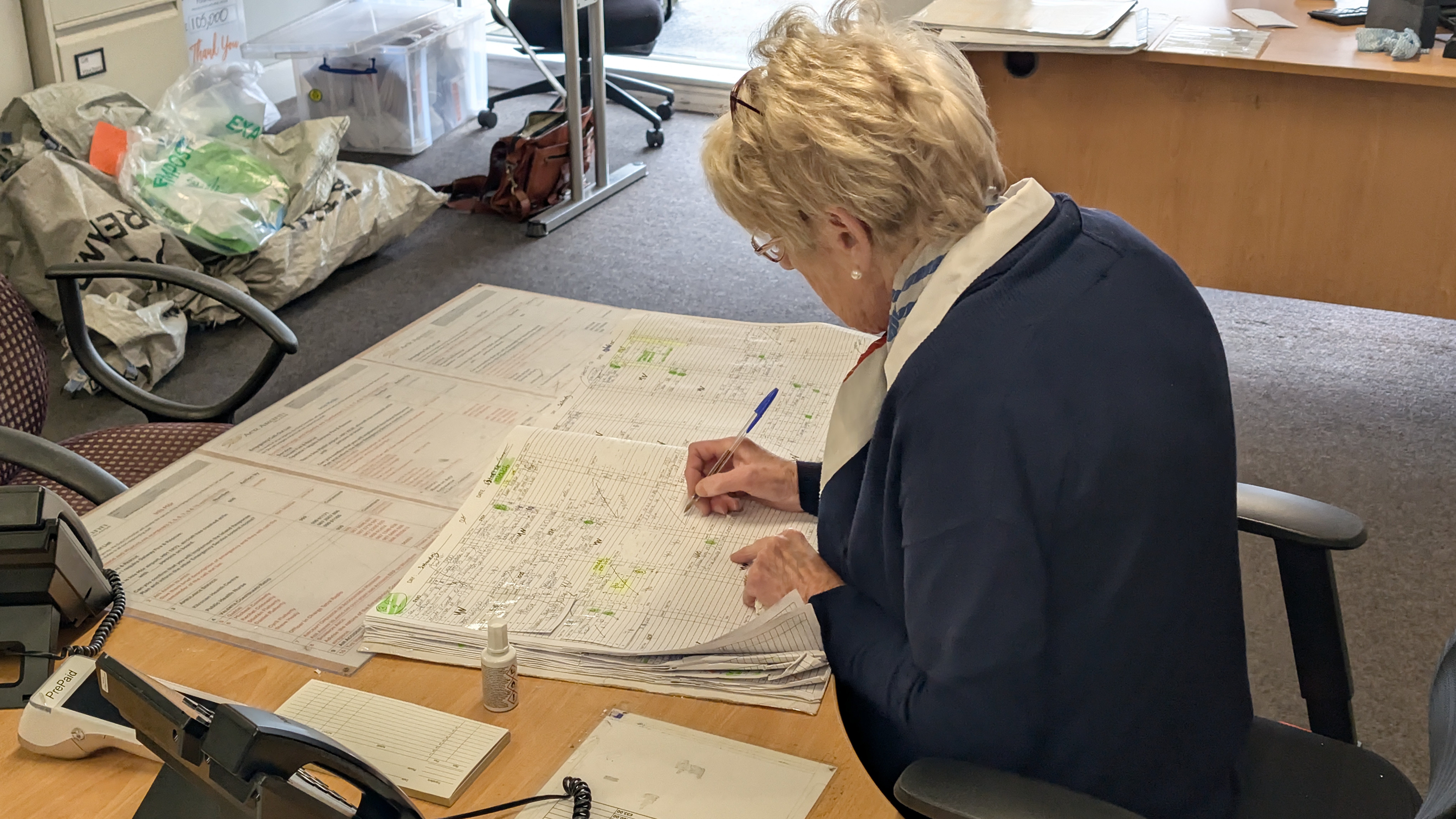 An Aer Arann Islands agent updating flight records by hand in the paper booking book at Connemara Airport, before the airline's move to Farel.
