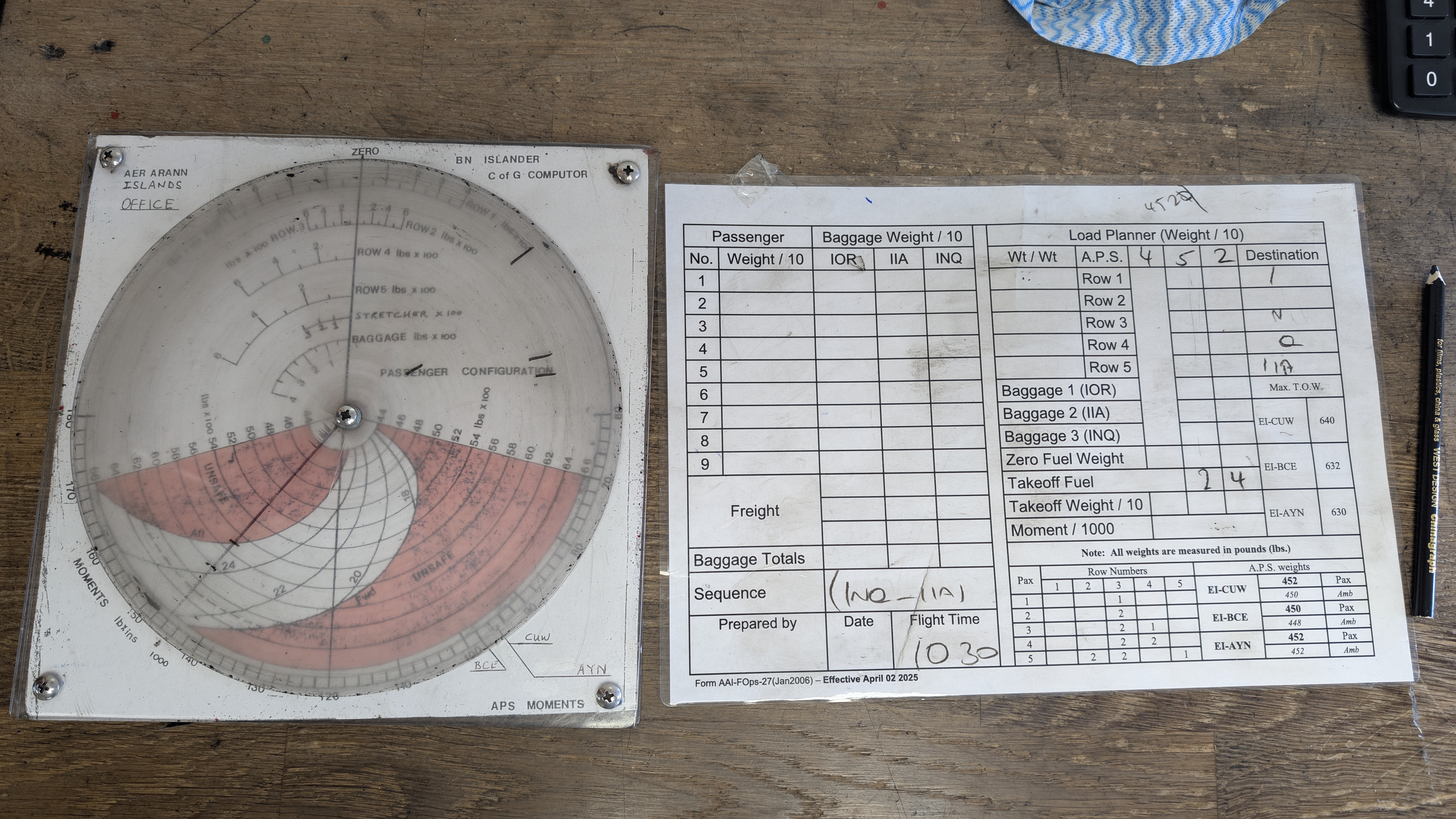 Aer Arann Islands' manual weight and balance tools: a rotating BN Islander center-of-gravity calculator disc and a handwritten load planner sheet.