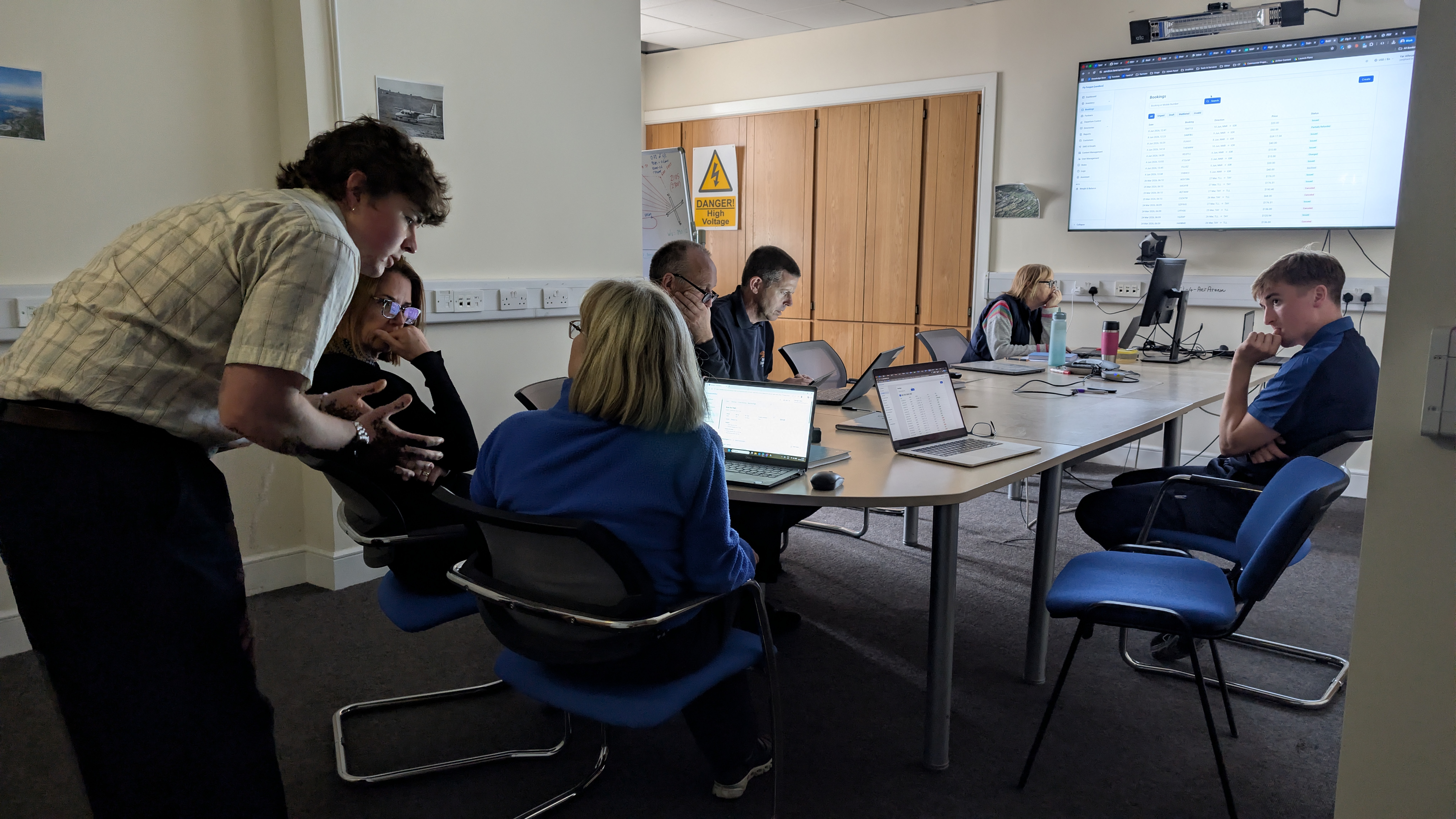 Farel training session at Aer Arann Islands: staff at laptops in the Connemara Airport meeting room with the Farel bookings screen on the wall display.