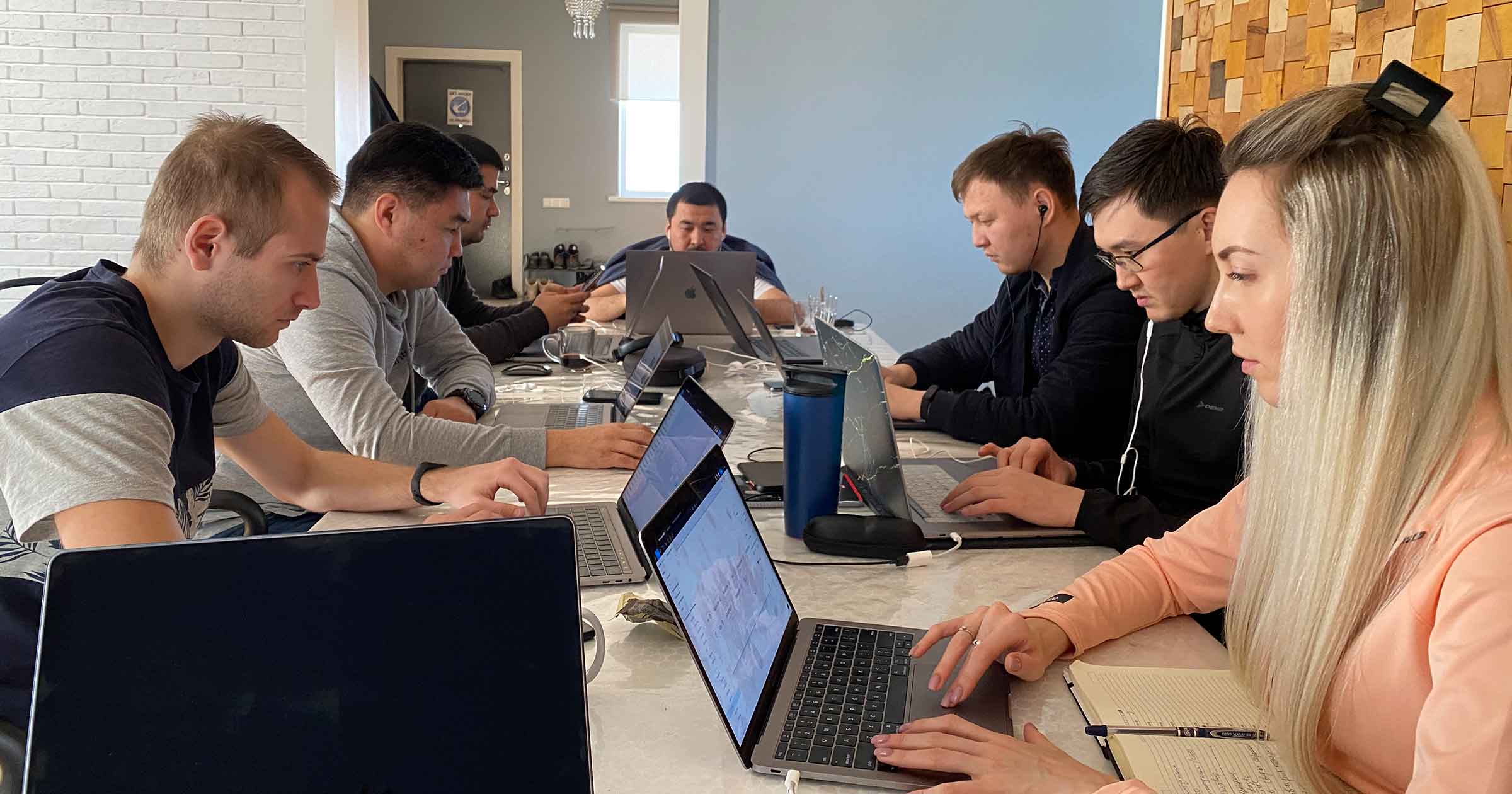Farel team working together with laptops around a long table in the early days