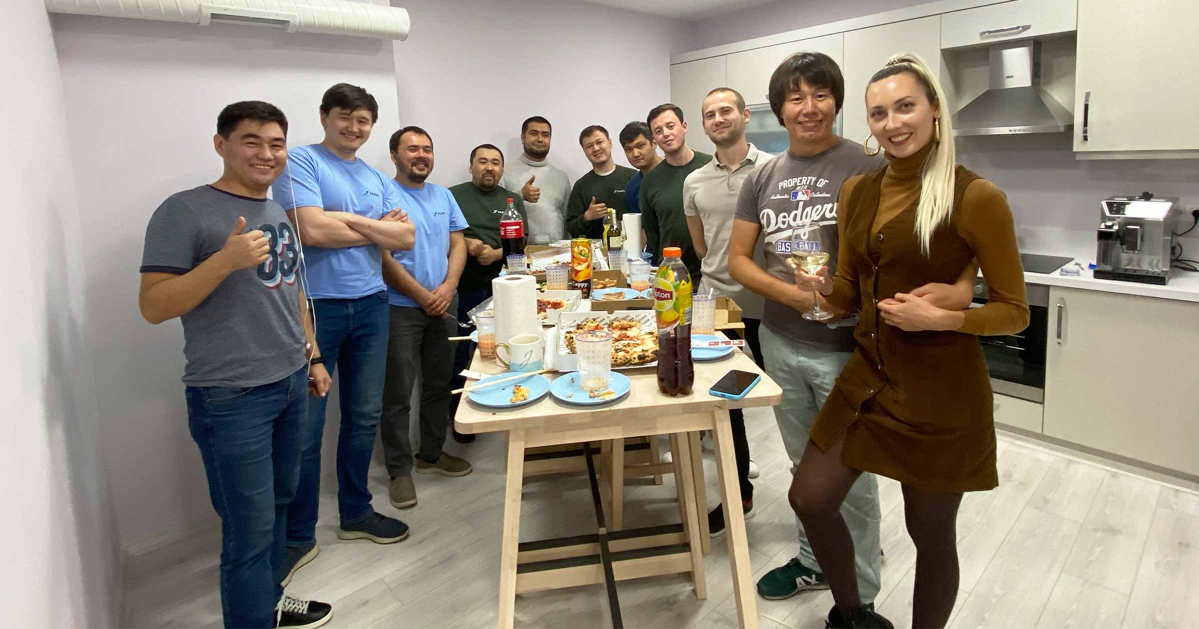 Farel team gathered around a kitchen table at the office, smiling at the camera